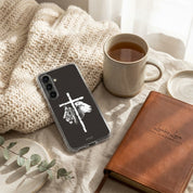 Christian Samsung phone case with cross and hand design, mug of tea, and leather notebook on textured surface