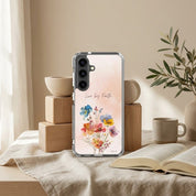 Samsung phone case with floral design and text on a table with books and plants