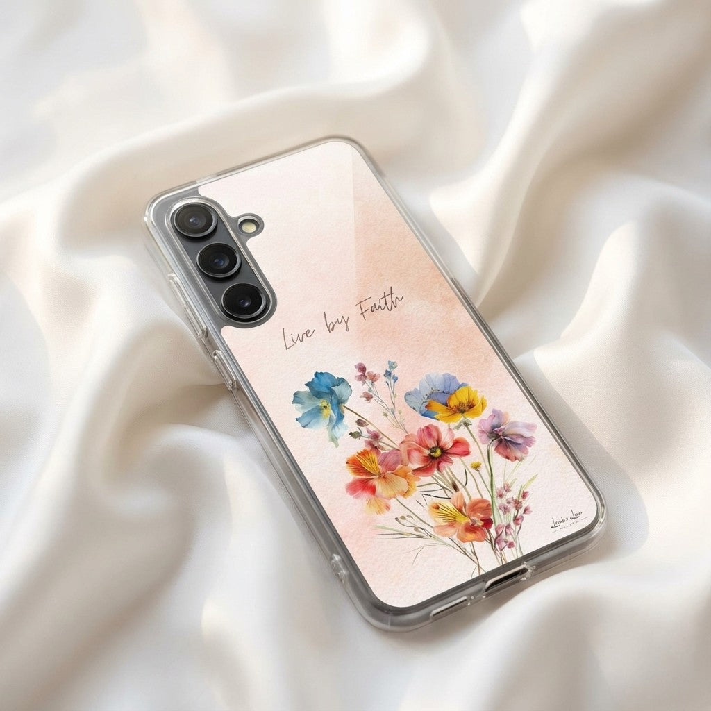 Samsung phone case with floral design and 'Live by Faith' text on a soft fabric background