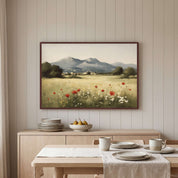 Framed vintage Christian landscape wall art titled Luke 12:27 featuring a meadow of red poppies and wildflowers with distant mountains, displayed on a beige paneled wall above a light wooden sideboard in a soft organic modern dining room.