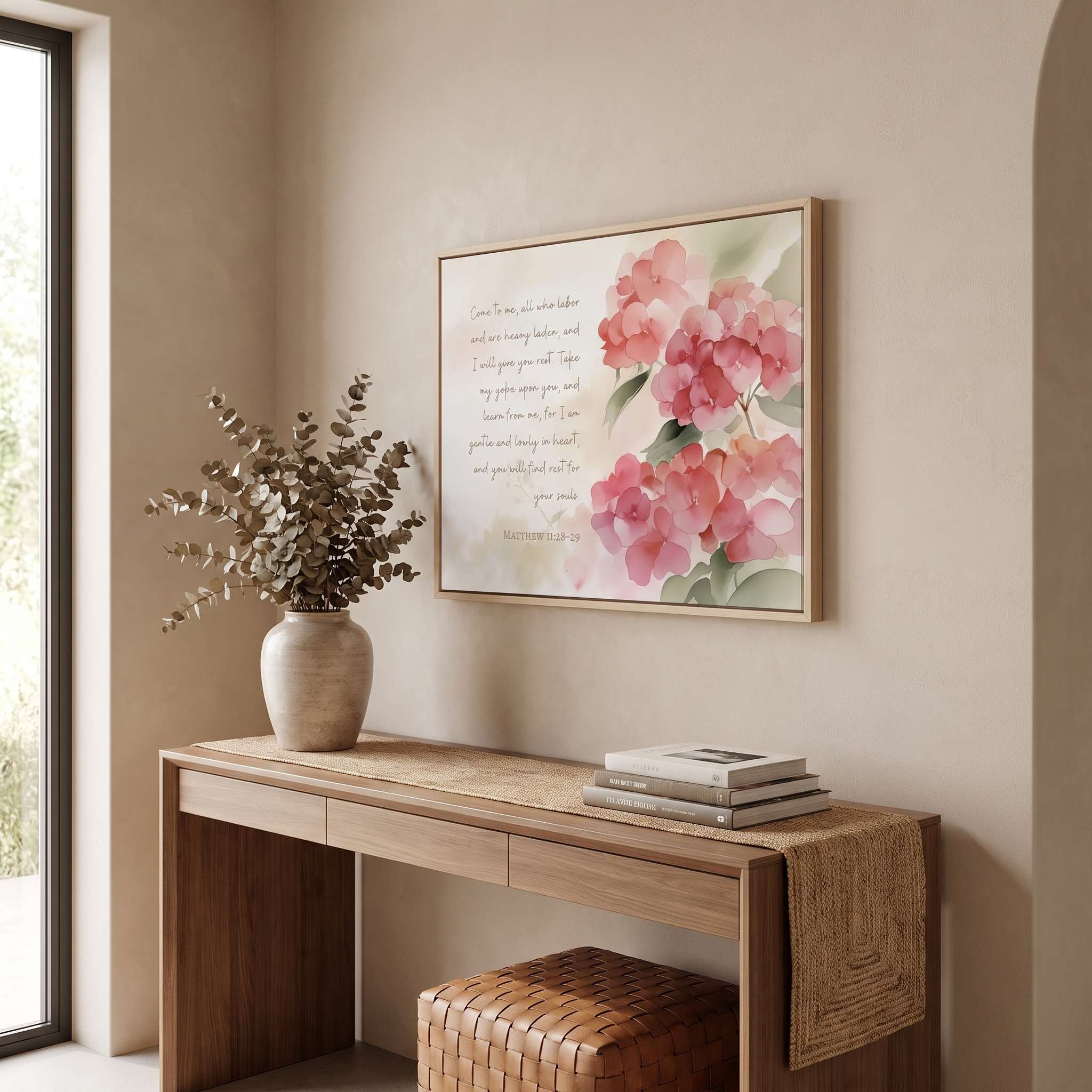 Framed Matthew 11:28 watercolor wall art with pink hydrangeas and scripture above a console table in a warm neutral entryway.