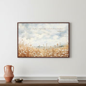 Matthew 6:28 'Do Not Worry' wildflower scripture wall art in a dark wood frame, styled above a wooden console with a terracotta vase and books for a minimalist home office.