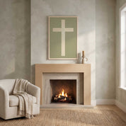 Minimalist ivory cross vertical framed canvas wall art on a sage green background displayed above a light wood fireplace mantel in an organic modern living room.