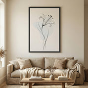 Minimalist Lily Line Art in a black frame hanging above a beige sofa with a textured cream throw blanket and a wooden coffee table.