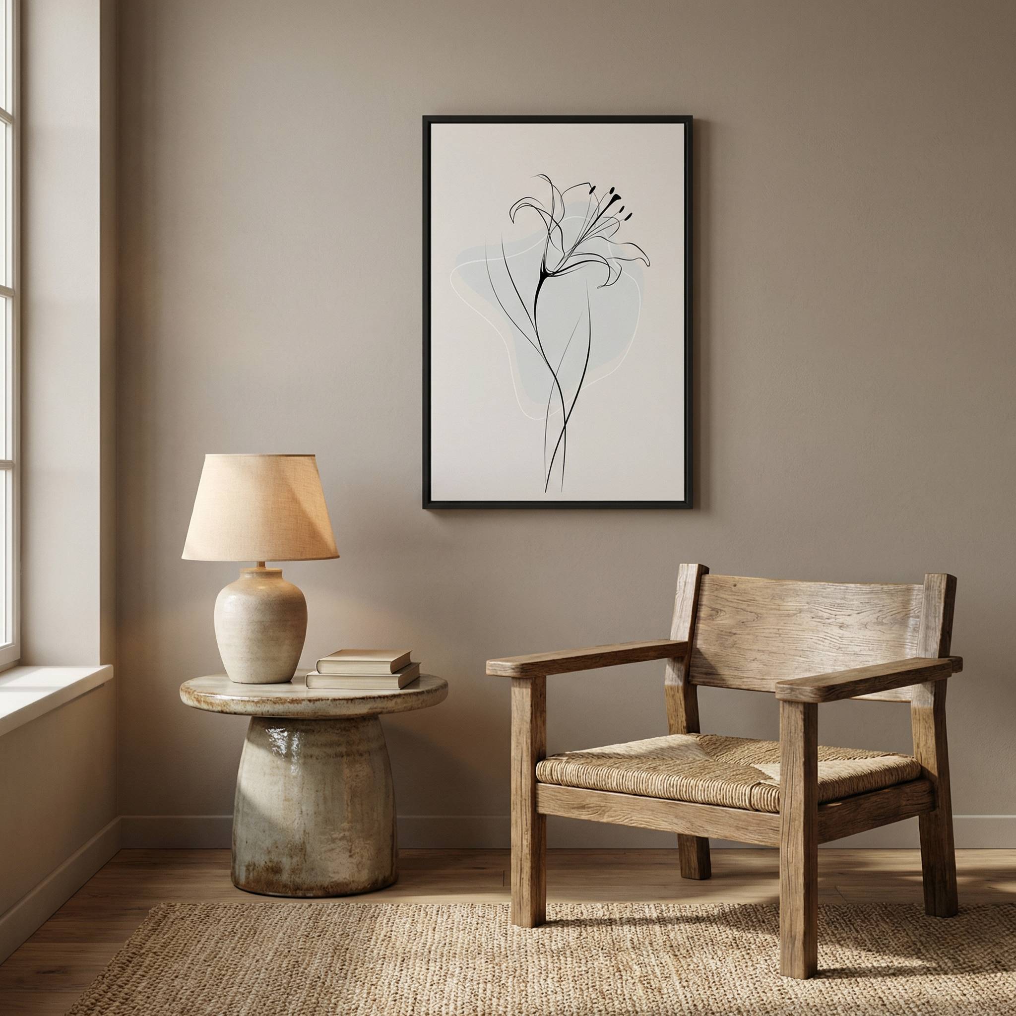 Minimalist Lily Line Art in a sleek black frame, hanging above a rustic wooden armchair and a stone-style side table with a ceramic lamp in a warm beige room.