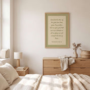 Minimalist Matthew 6:28–29 Scripture vertical framed canvas Christian wall art in soft sage green displayed on a neutral wall above a light wood dresser in an organic modern bedroom.