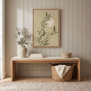 Minimalist olive branch vertical framed canvas Christian wall art in soft sage green with rising sun displayed on a paneled wall above a light wood bench in an organic modern entryway.