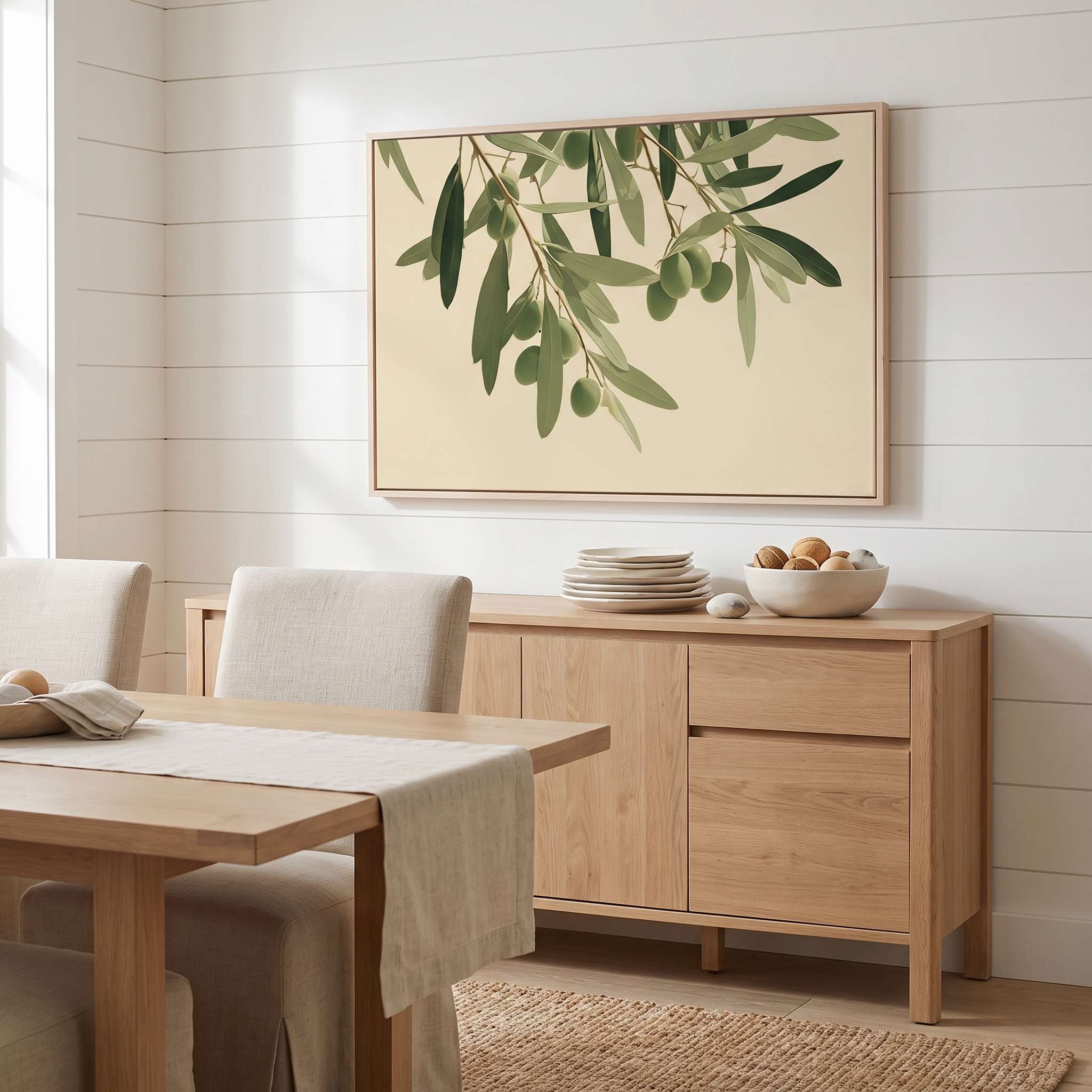 Minimalist olive branch horizontal framed canvas artwork displayed on a white shiplap wall above a light wood sideboard in an organic modern dining room.