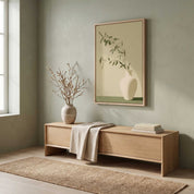 Minimalist olive branch in a white ceramic vase vertical framed canvas Christian wall art in soft sage green displayed on a muted green wall above a light wood bench in an organic modern entryway.