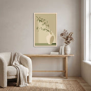 Minimalist olive branch in a white ceramic vase vertical framed canvas Christian wall art in soft sage green displayed on a beige wall above a light wood console table beside a cream armchair in an organic modern living room.