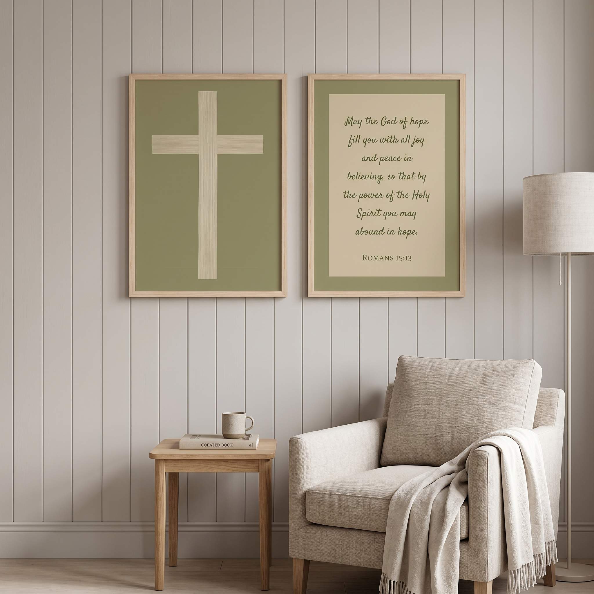 Minimalist Romans 15:13 Scripture and ivory cross 2-piece framed poster wall art set displayed on a vertical paneled wall above a beige armchair in an organic modern reading nook.