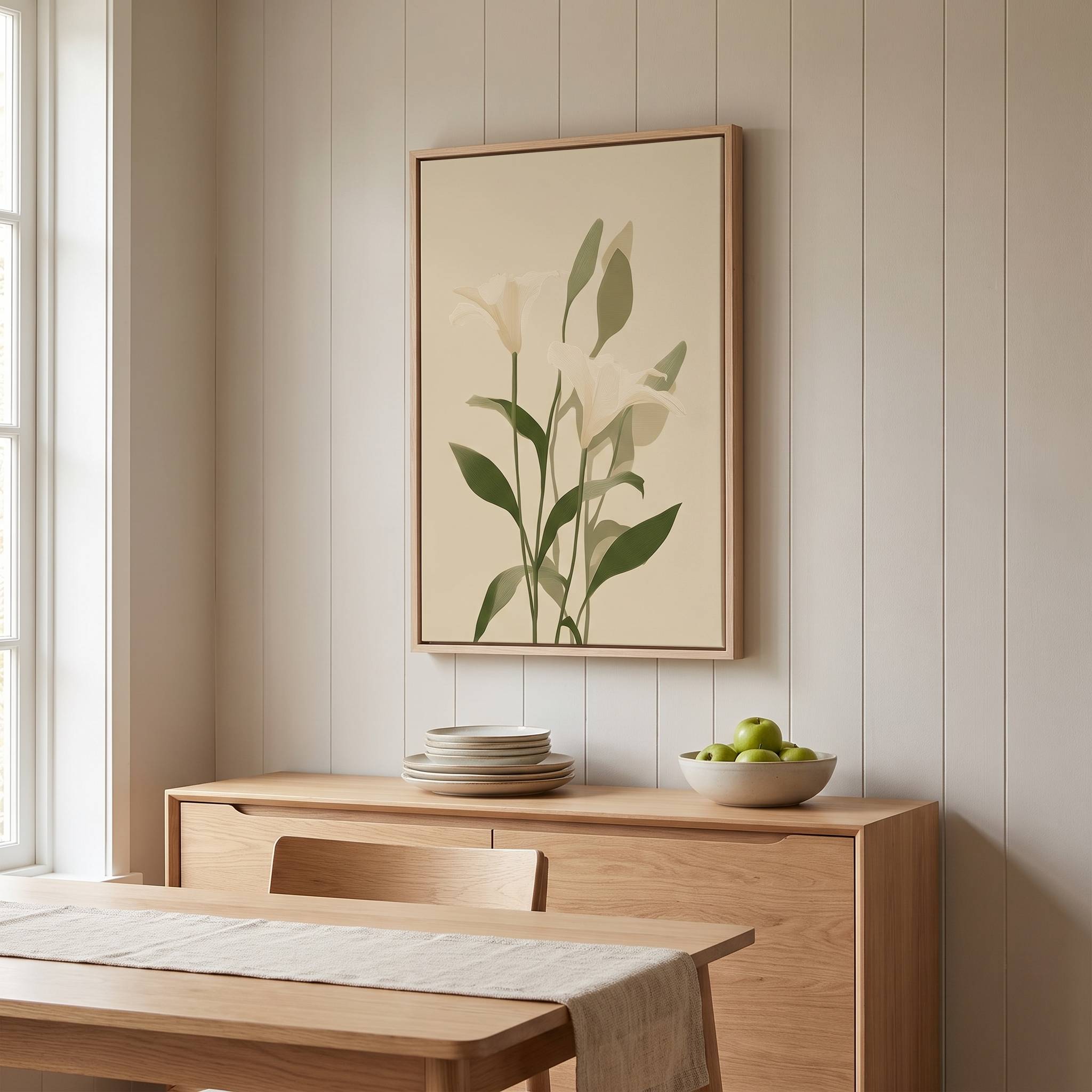 Minimalist white lily vertical framed canvas Christian wall art in soft sage green displayed on a paneled wall above a light wood sideboard in an organic modern dining room.