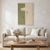 Minimalist white poppy vertical framed canvas wall art displayed on a textured beige wall above a neutral sofa in an organic modern living room.