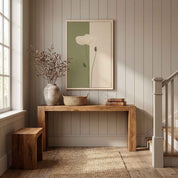 Minimalist white poppy vertical framed canvas wall art displayed on a paneled wall above a light wood console table in a staircase entryway.