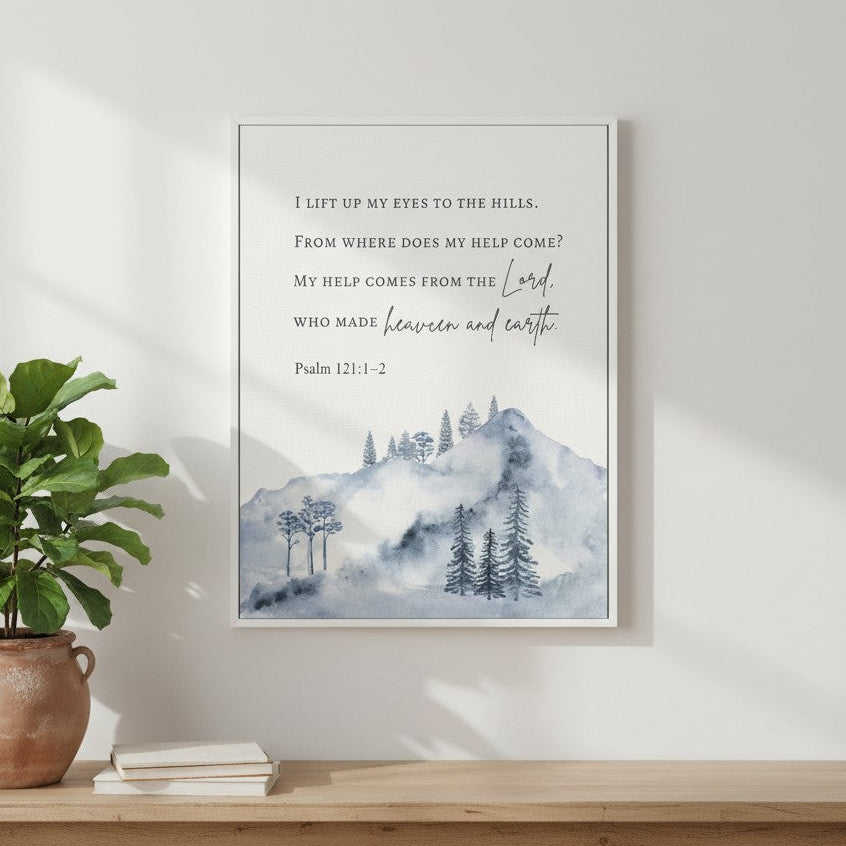 Watercolor mountain Christian wall art with Psalm 121:1–2, “My help comes from the Lord,” displayed above a wooden bench with soft natural light and a green plant.