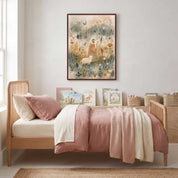 My Shepherd Jesus and lamb Christian kids wall art in a dark wood frame above a wooden bed with blush pink and cream bedding and children’s books.