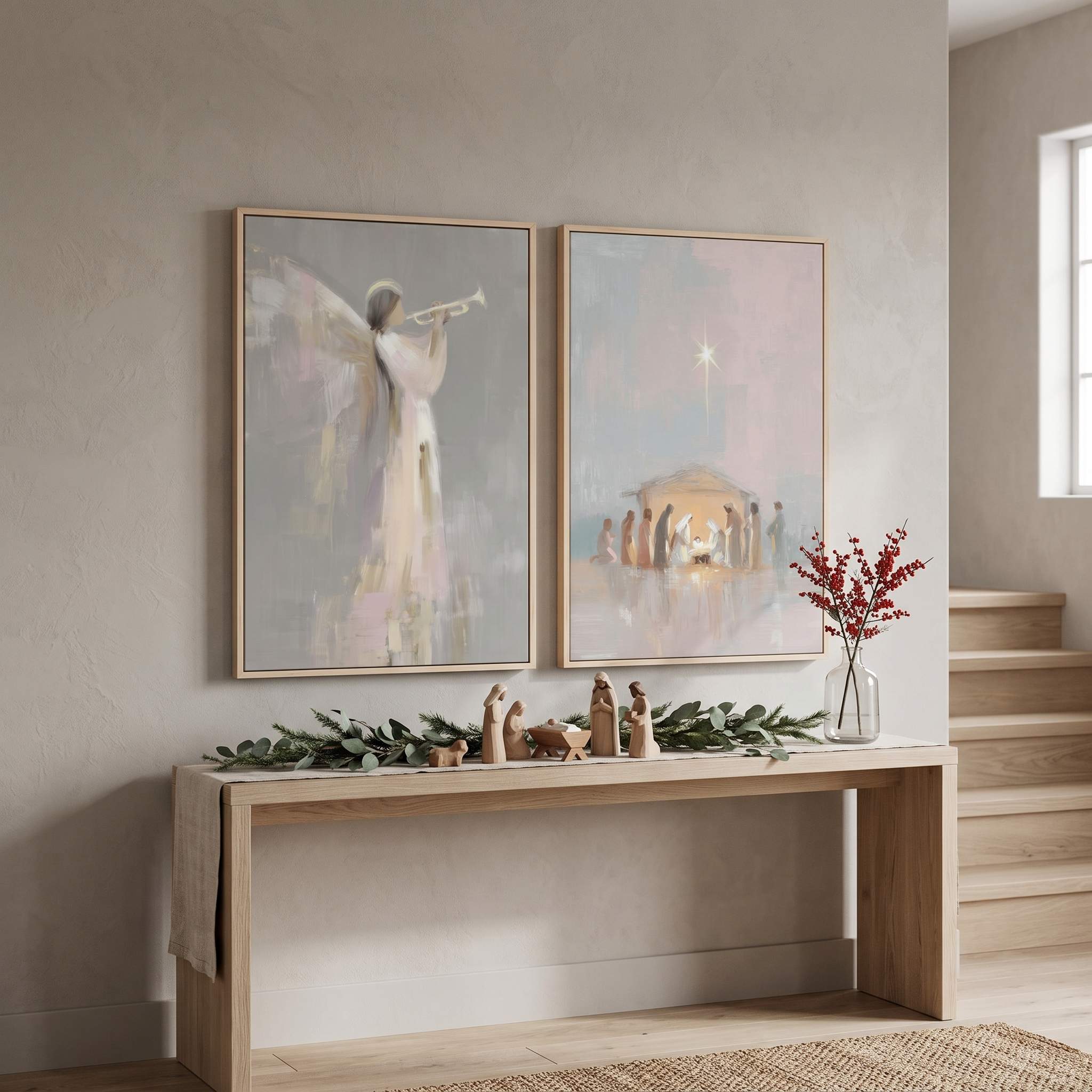 Christian Christmas wall art diptych with a Nativity scene and angel print above a console decorated with a wooden manger display and greenery.
