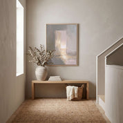Open door Jesus Christian wall art in a bright staircase hallway, styled above a natural wood console with a vase, books, and woven basket.