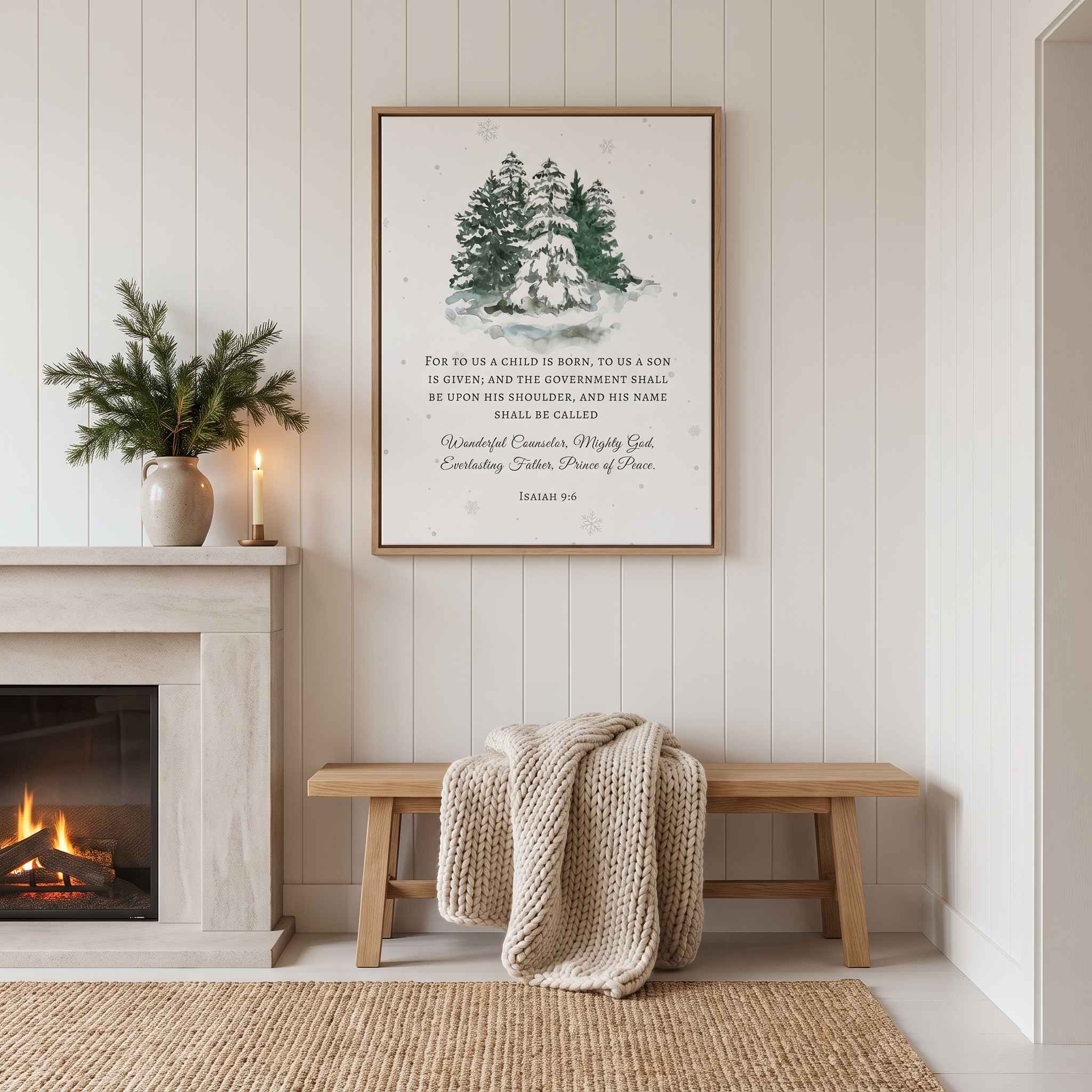 Our Savior Is Born Isaiah 9:6 framed canvas print with watercolor snowy pine trees displayed on a white paneled wall above a wooden bench next to a cozy fireplace.