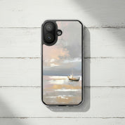 Peace Be Still MagSafe® clear iPhone case featuring a peaceful boat on calm ocean waters, displayed on a rustic white wood surface in a minimalist coastal setting
