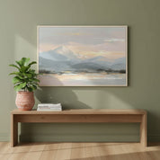 Mountain wall art with gentle sunrise hues of blush and blue, styled in a cozy green living room with natural light.