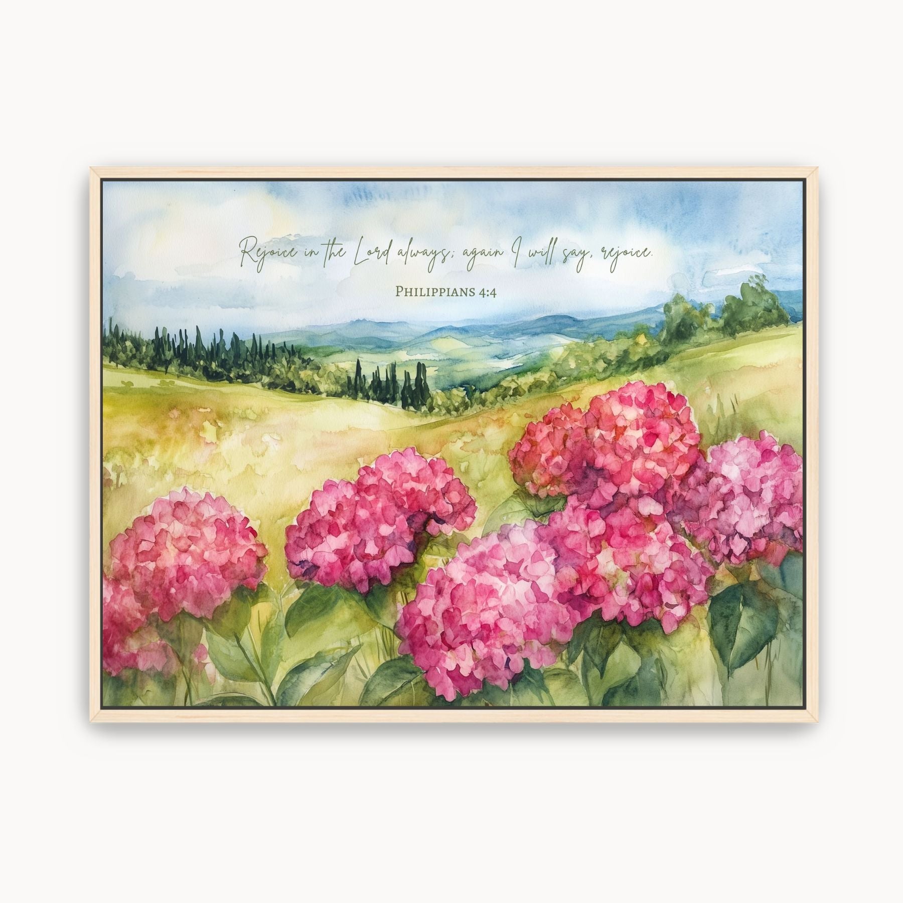 Framed watercolor wall art with pink hydrangeas, a green countryside landscape, and Philippians 4:4 scripture, Rejoice in the Lord.