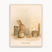Pray Always Christian kids wall art showing a little bunny praying beside a bed, with a bedside lamp and warm cream tones in a light wood frame.