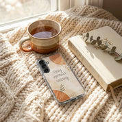 Christian phone case with motivational quote on a cozy setting with a mug of tea and a Bible.