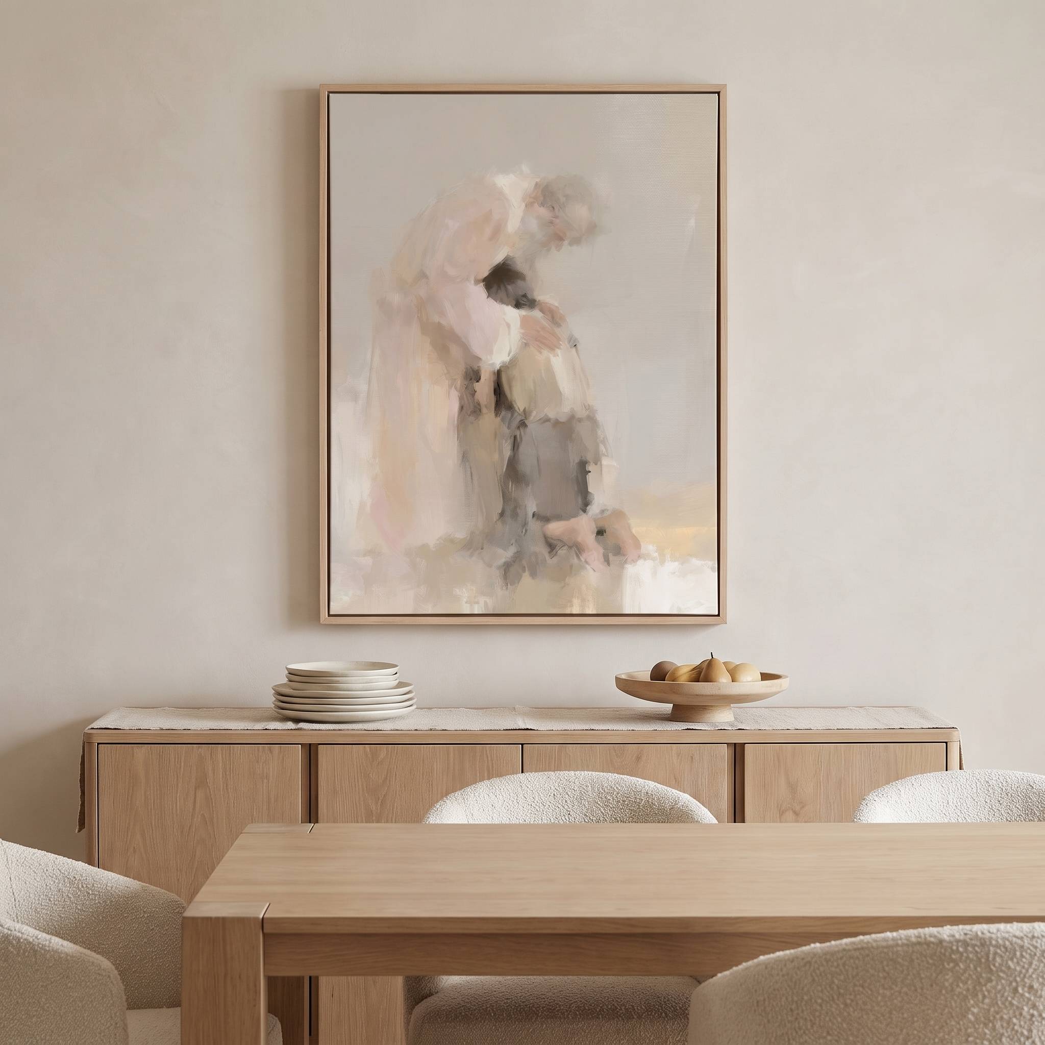 Framed watercolor Prodigal Son Christian wall art of a father embracing his returning son, displayed above a light wood dining sideboard with plates and pears.
