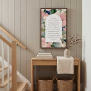 Framed vintage Christian floral wall art titled Psalm 23:1–4 featuring "The Lord is my shepherd" with watercolor florals, displayed on a greige paneled wall above a light wooden console table in a soft organic modern staircase hallway.