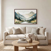 Framed vintage Christian mountain landscape wall art titled Psalm 33:5 featuring mountains, pine trees, and a river, displayed on a light beige wall above a beige sofa in a soft organic modern living room.