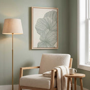 Framed minimalist palm leaf Scripture wall art titled Psalm 92:12–15 featuring "Flourish in Faith" with green line art artwork, displayed in a light wood frame on a sage green wall above a cream bouclé armchair and floor lamp in a soft organic modern reading nook.