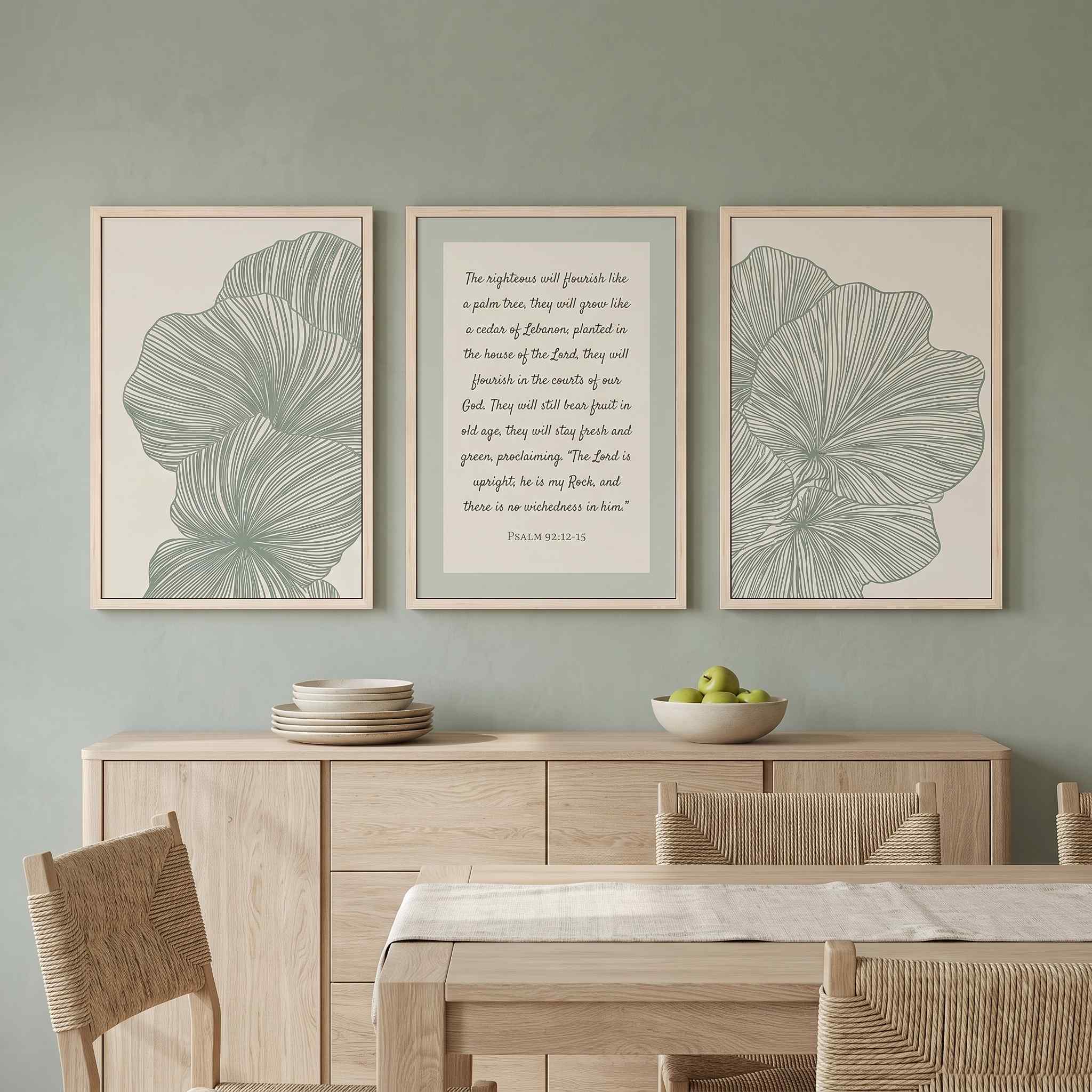 Three-piece framed canvas gallery wall set featuring Psalm 92:12–15 "The righteous will flourish like a palm tree" flanked by two sage green minimalist leaf line art prints, displayed in light wood frames on a sage green wall above a light wood sideboard in a soft organic modern dining room.