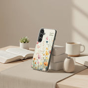 Rejoice Always Christian Samsung phone case with colorful wildflower floral design leaning against a stack of white books on a desk with an open Bible, a succulent, and a coffee mug.