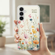 Rejoice Always Christian Samsung phone case with colorful watercolor wildflower design and uplifting faith message, held by a hand in a bright indoor setting.