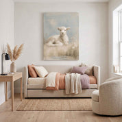 Rest by Still Waters Christian lamb canvas wall art above a cream upholstered daybed with muted pink and mauve bedding in a bright room beside a desk and reading chair.
