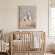 Rest by Still Waters Christian lamb framed canvas above a light wood crib in a cream nursery with textured wallpaper and a cushioned rocking chair.