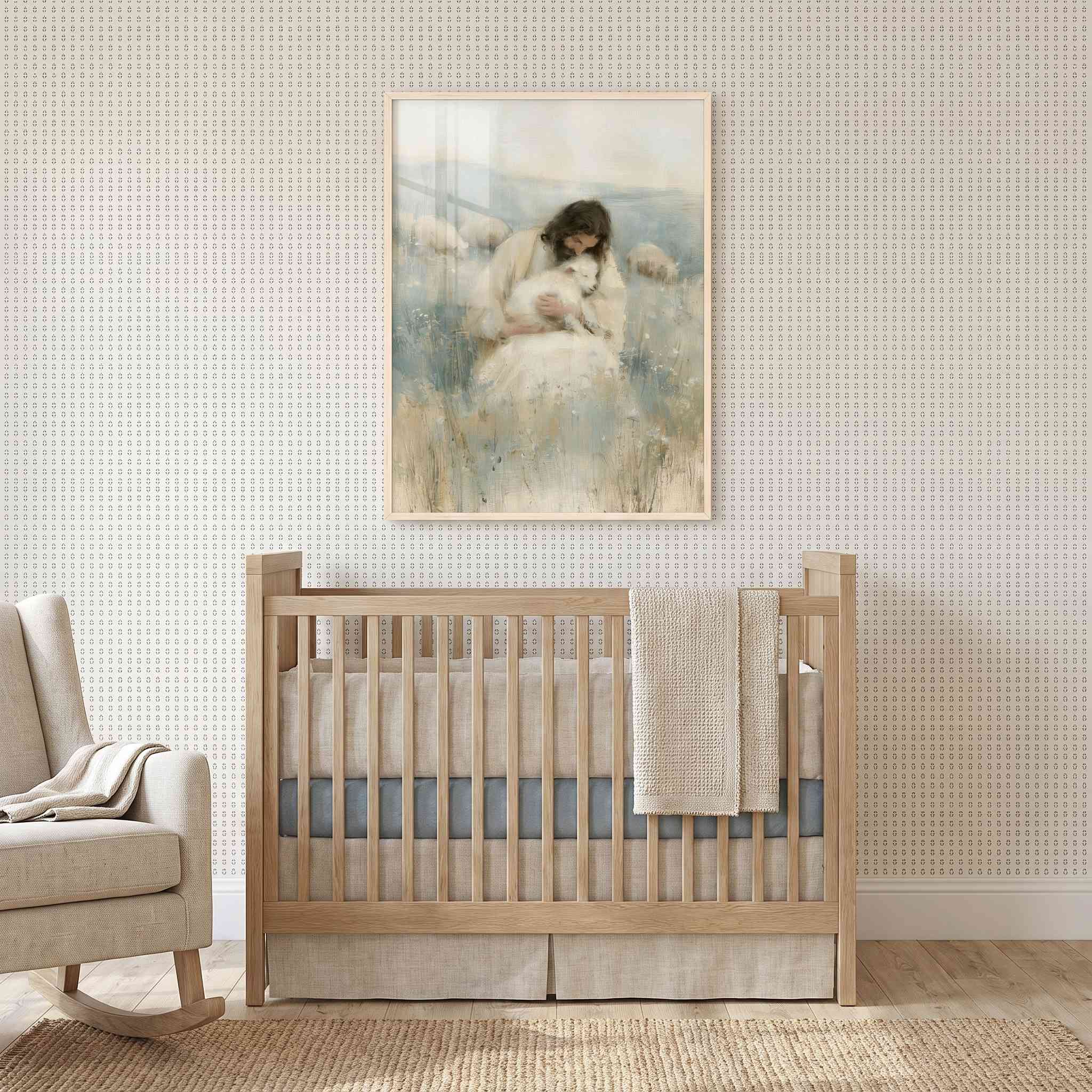 Rest in His Arms Jesus holding a lamb Christian nursery wall art in a light wood frame above a wooden crib beside a cream rocking chair.