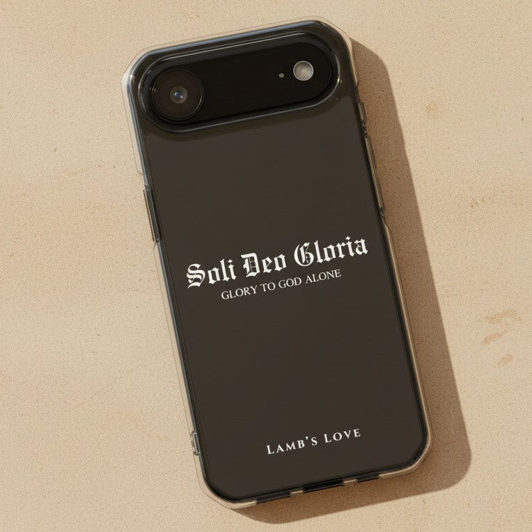 Christian MagSafe iPhone case featuring Soli Deo Gloria “Glory to God Alone” design on a black phone case with textured sandstone background