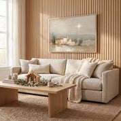 Framed vintage Christmas Christian wall art titled The Star Over Bethlehem, depicting the glowing star above Bethlehem, displayed above a beige sofa in a soft organic modern living room.