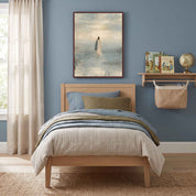 Framed Take Courage Jesus walking on water Christian wall art above a wooden single bed against a blue wall, beside children’s books and a globe.