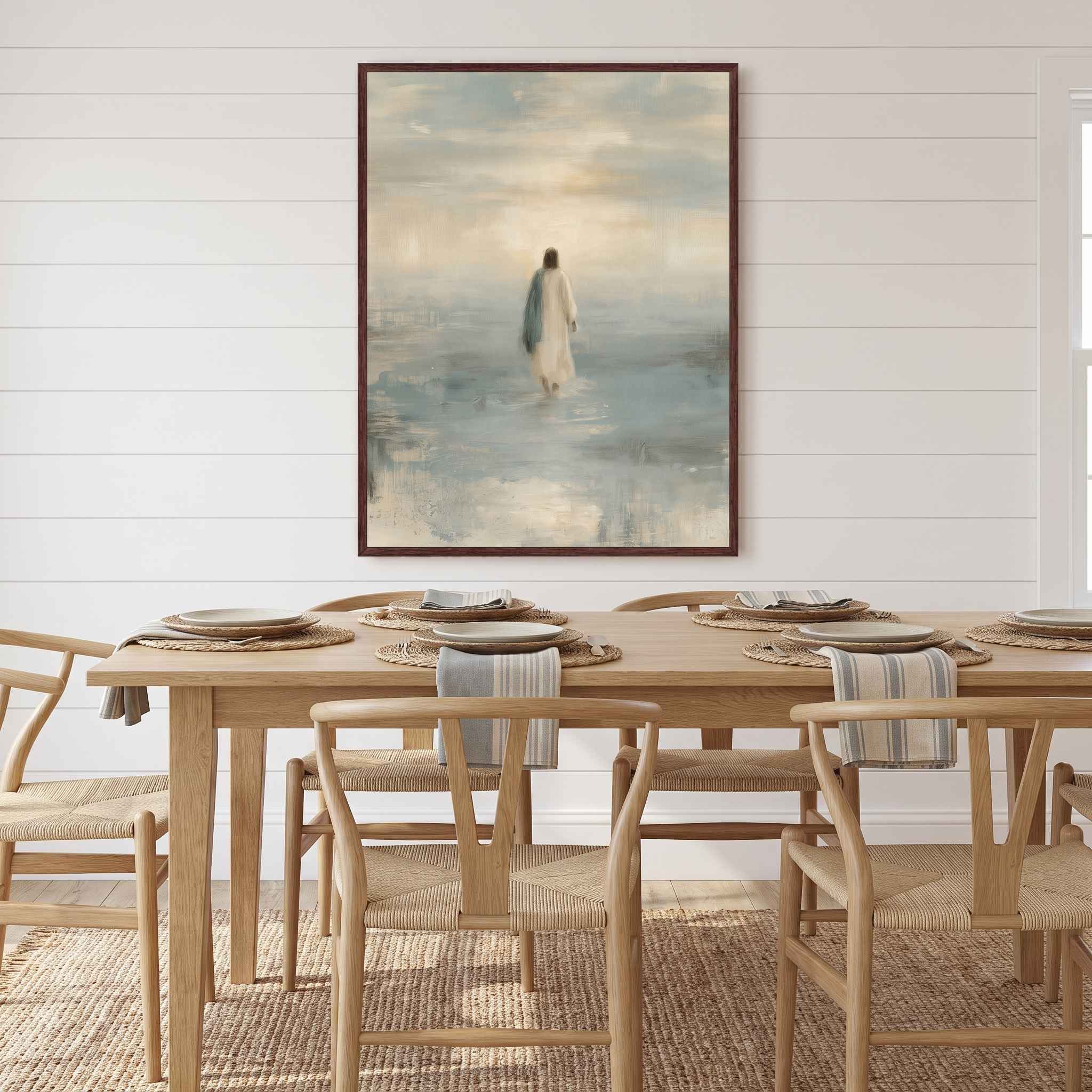 Framed Take Courage Jesus walking on water Christian wall art on a white paneled wall behind a wooden dining table with woven chairs and place settings.
