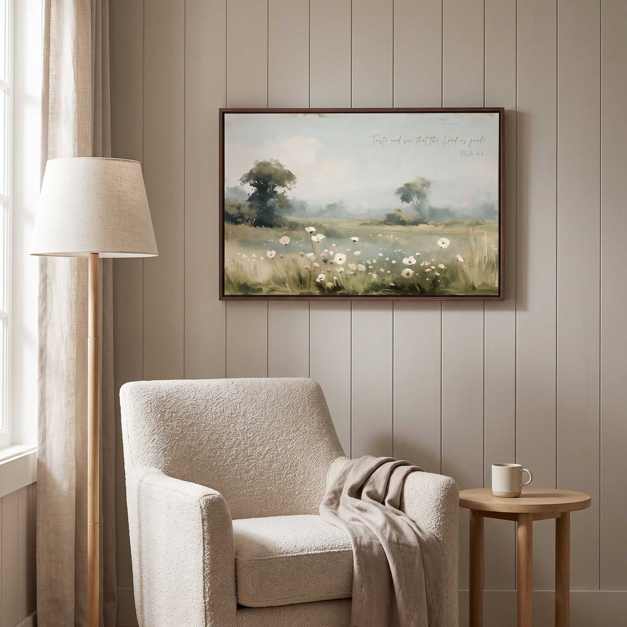 Framed vintage Psalm 34:8 wildflower landscape canvas wall art hanging on a paneled wall above a beige boucle armchair and small wooden side table in a soft organic modern reading nook.