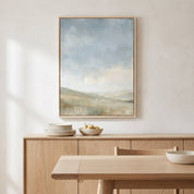 Framed The Earth Is the Lord’s Christian landscape wall art above a light wood dining room sideboard with plates and a bowl of pears.