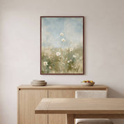 Framed The Father Cares for You Christian wildflower wall art above a light wood dining room sideboard with stacked plates and a fruit bowl.