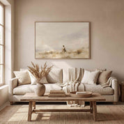 Framed vintage fine art canvas painting of Jesus leading sheep hanging on a light beige wall above a beige sofa with throw pillows and a wooden coffee table in a modern organic living room.