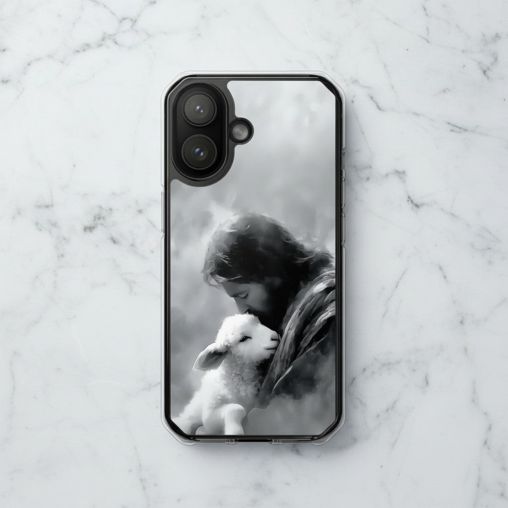 The Good Shepherd MagSafe® clear iPhone case featuring black and white watercolor artwork of Jesus holding a lamb displayed on a white marble surface in a minimalist Christian aesthetic setting