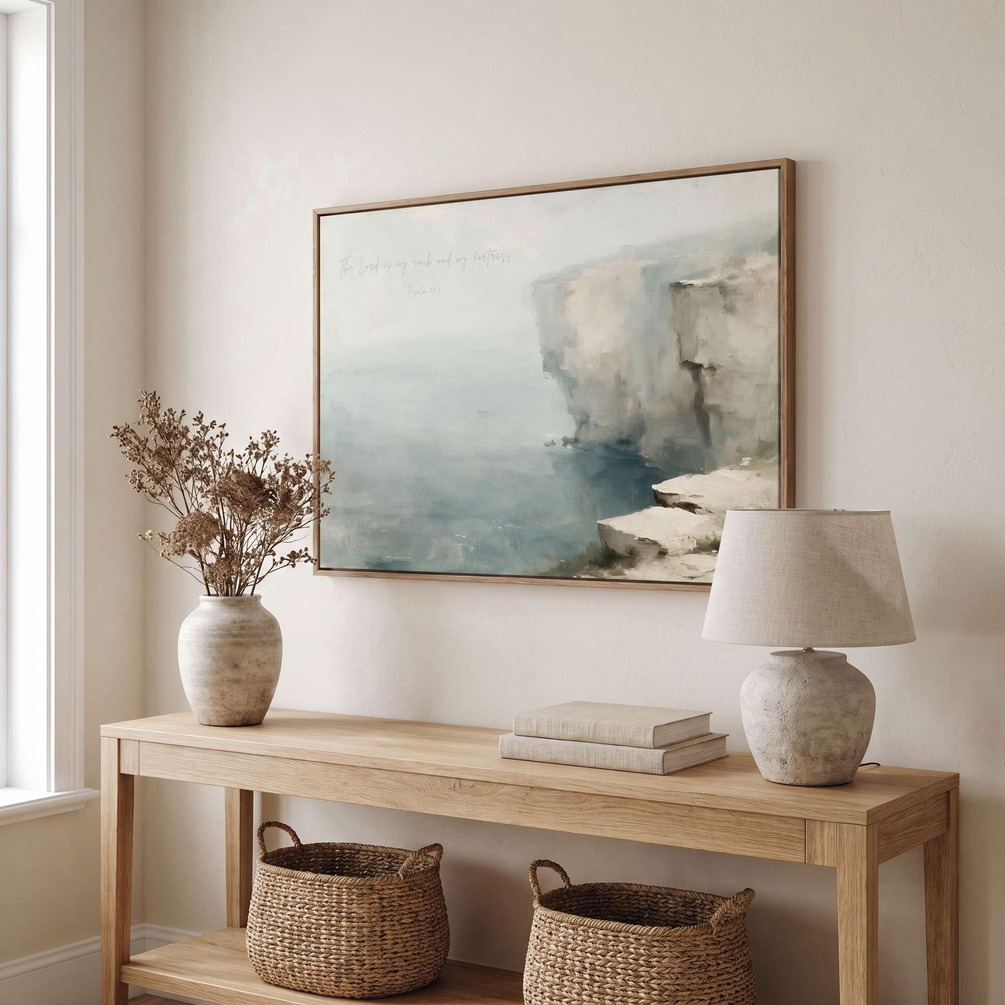 Framed vintage Psalm 18:2 Christian landscape canvas wall art featuring a coastal cliff scene hanging above a light wooden console table in a soft organic modern entryway.