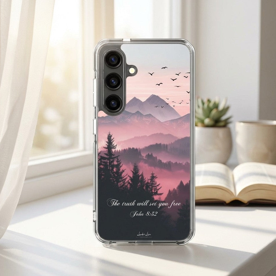 Phone case with mountain and tree design on a desk with a book and mug
