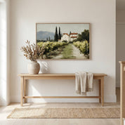 The Vineyard Christian landscape wall art displayed above a wooden entryway console table, featuring a peaceful vineyard and countryside home that symbolizes abiding in Christ, spiritual growth, and God's faithful provision.